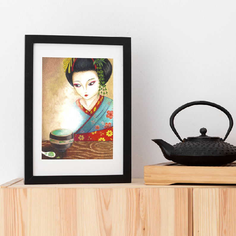 Stampa con geisha, incorniciata e poggiata accanto a una teiera in ghisa